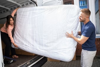 bigstock-Couple-Unloading-Mattress-From-381744140