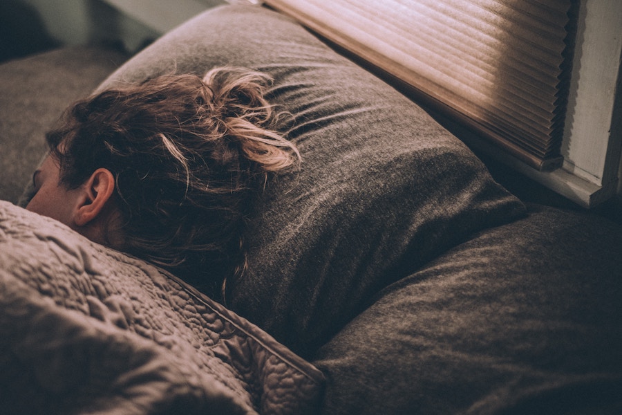 woman sleeping on sheets and pillow